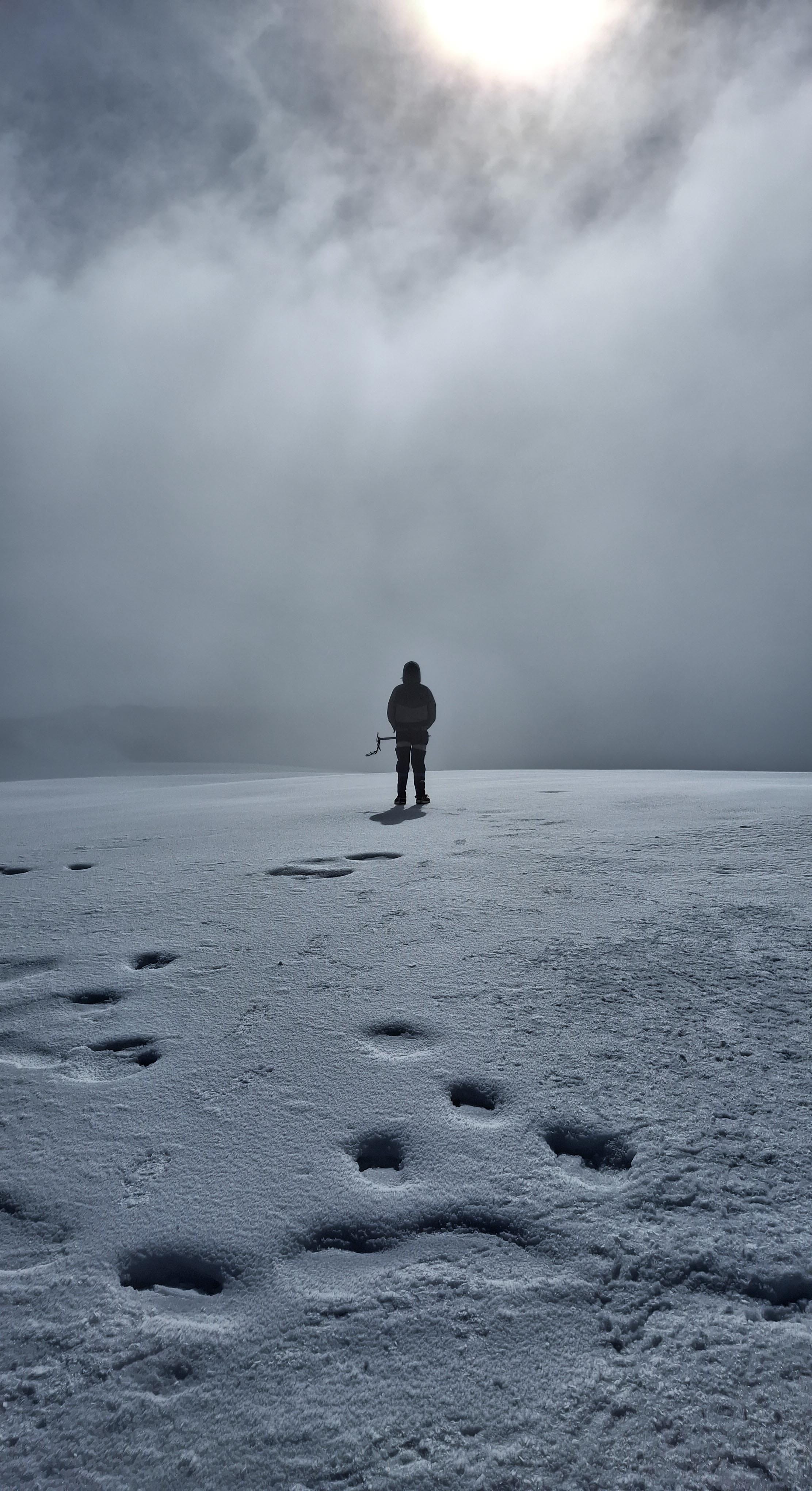 Person on a mountain peak looking at the moon